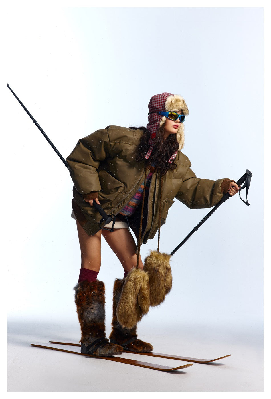 Model wearing an oversized olive-brown puffer jacket, shown from the front in a ski-inspired outfit.