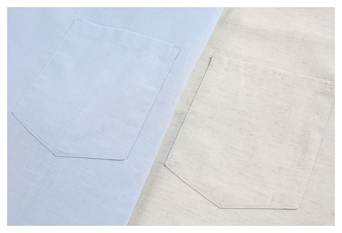 Close-up of square chest pockets on light blue and cream shirts.