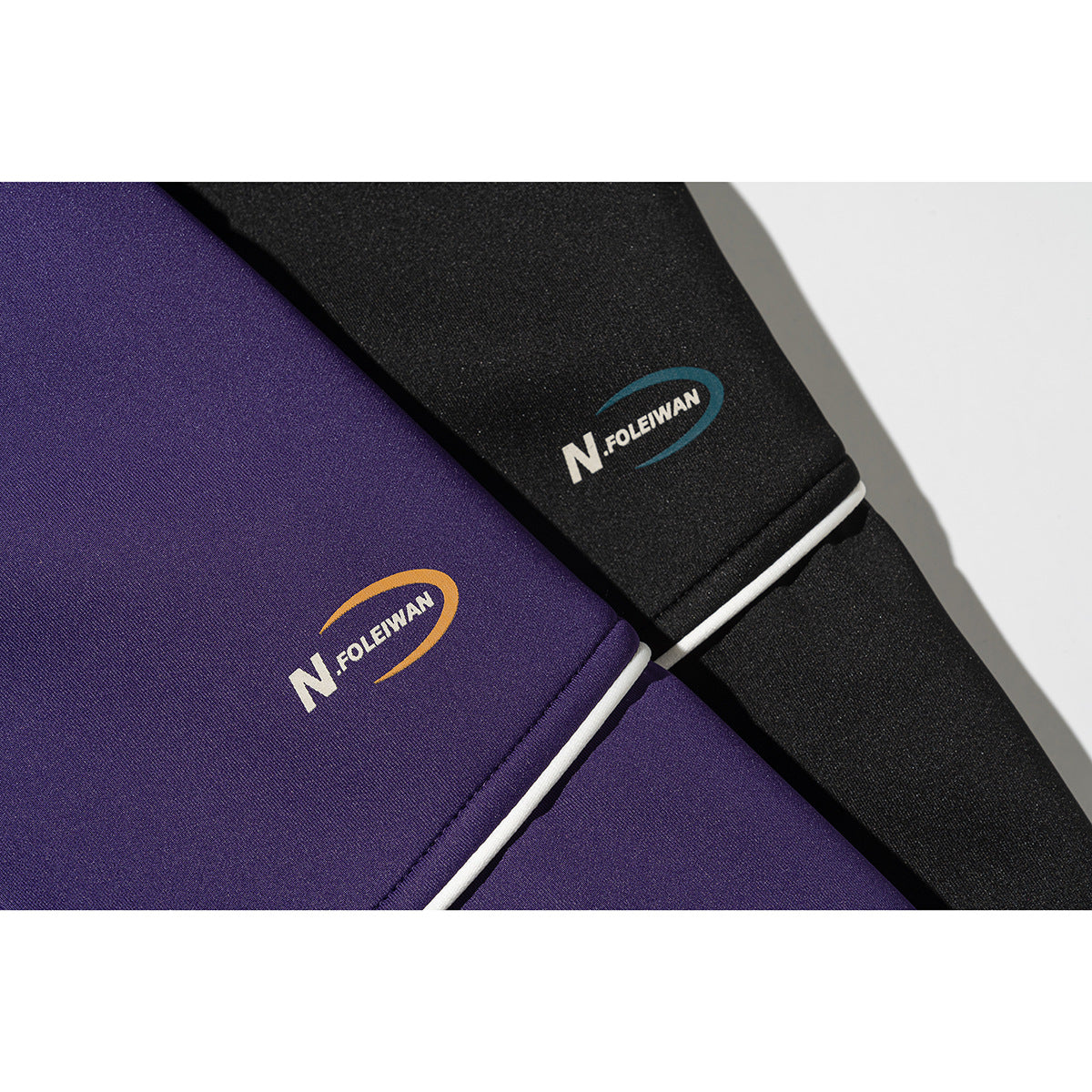 Close-up of purple and black jacket fabric with white piping and small chest logos.