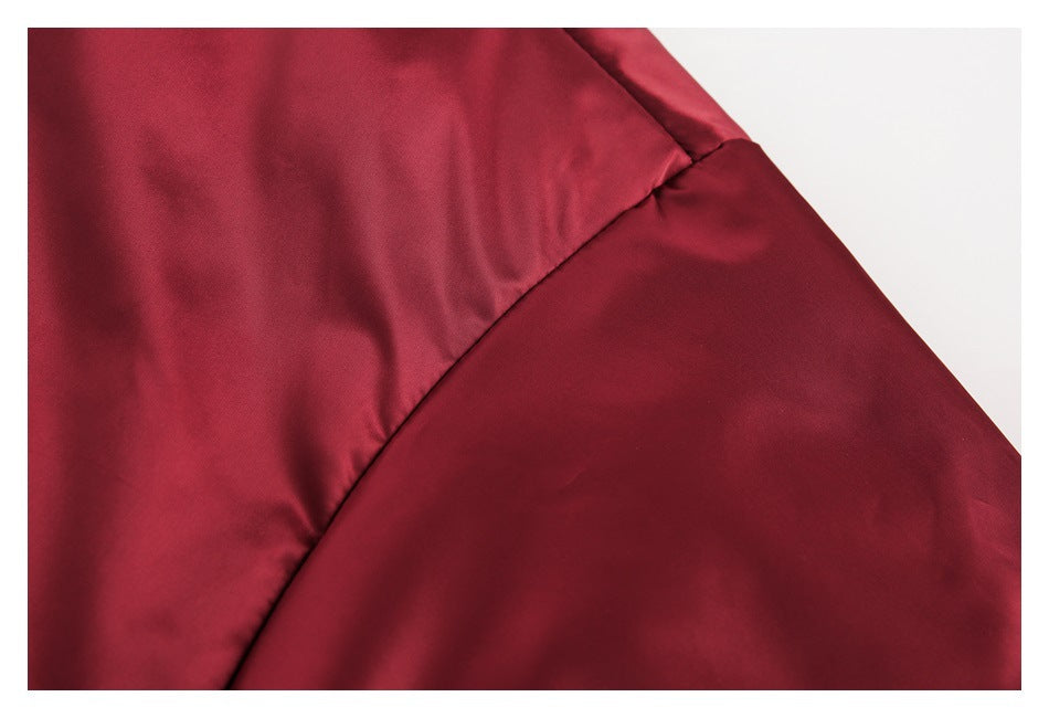 Close-up of the burgundy bomber jacket's sleeve and shoulder seam.