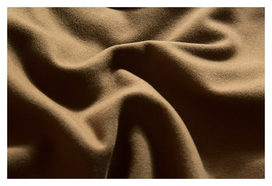 Extreme close-up of the brown jacket's textured fabric folds.