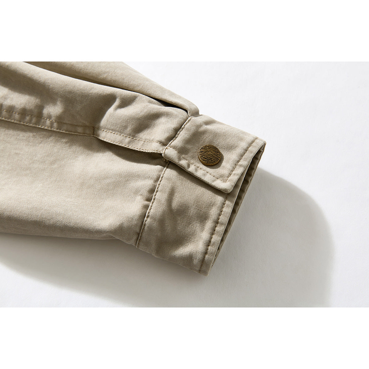Close-up of a beige jacket sleeve cuff with a dark round button.