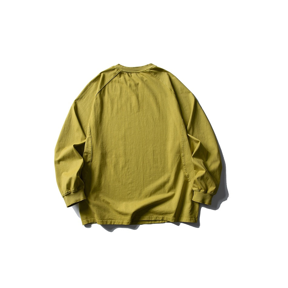 Back view of a mustard yellow-green long-sleeve raglan crewneck top with ribbed cuffs and neckline.