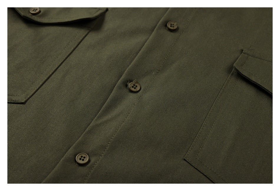 Close-up of the olive-green shirt's button placket, stitching and edge of a chest pocket.