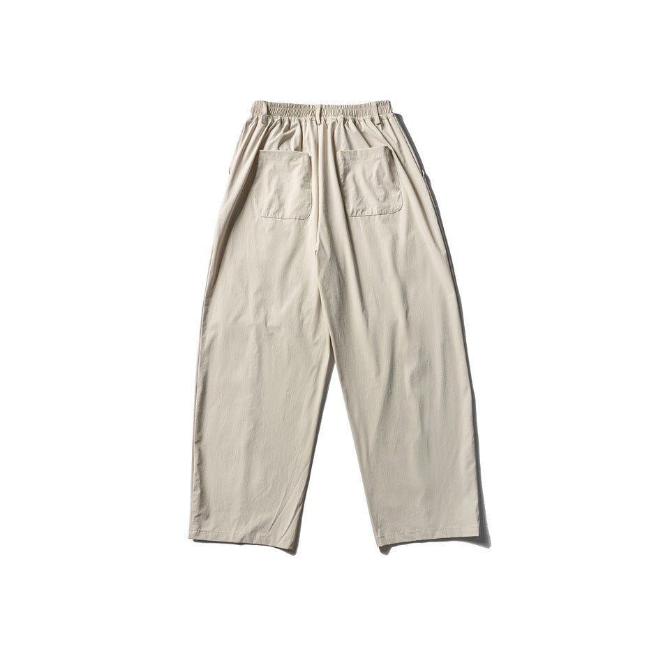 Back view of cream wide-leg trousers with an elasticated waistband and two patch pockets.