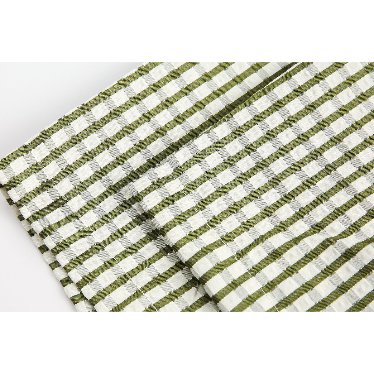Close-up of olive-and-white striped fabric with a raised woven texture and intersecting lines.