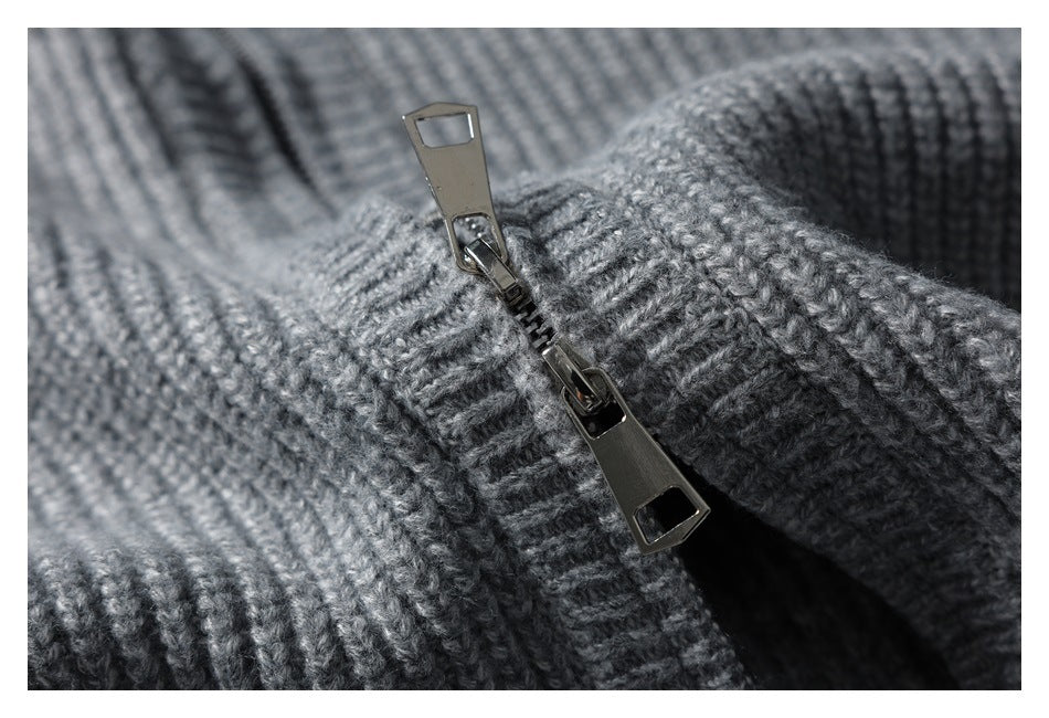 Close-up of the metal zipper and ribbed knit fabric on a gray garment.