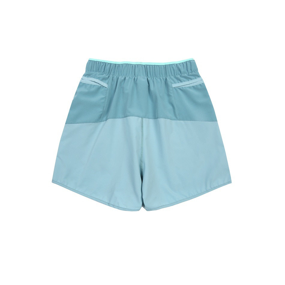 Rear view of aqua and light blue color-block shorts with an elastic waistband and two back pockets.
