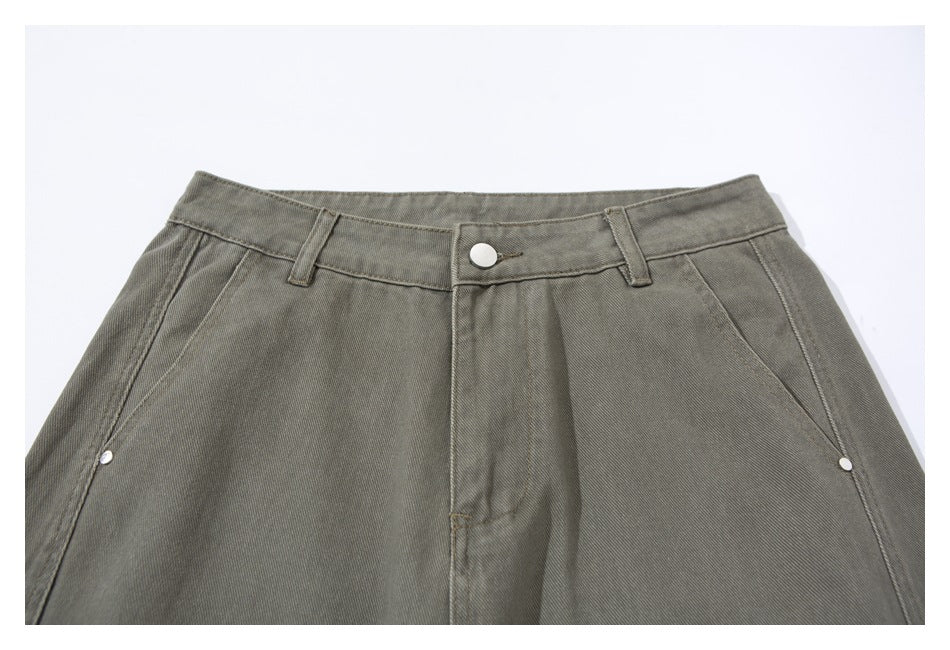 Front close-up of olive-gray pants showing the waistband, button closure, belt loops, and angled pockets.