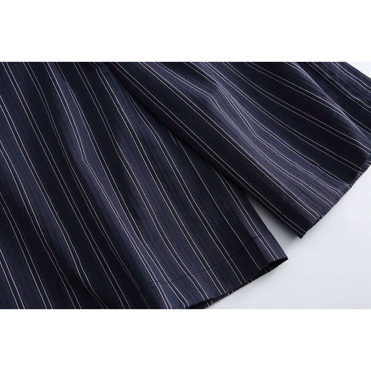 Close-up of the hems and vertical pinstripes on navy shorts.