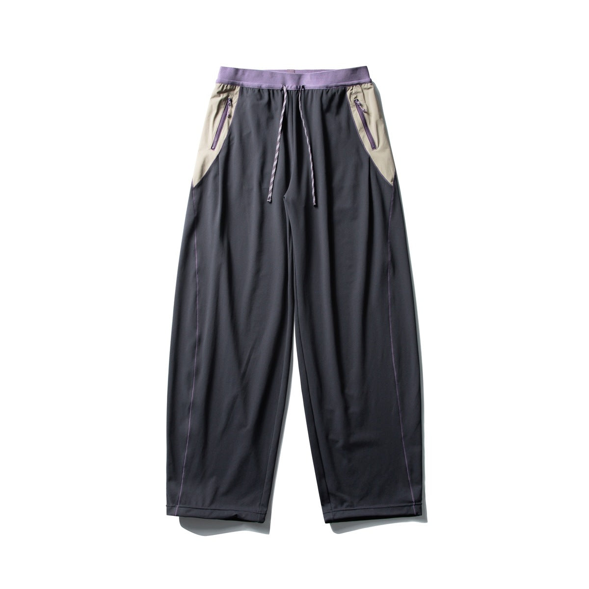 Black wide-leg pants with a purple ribbed waistband, beige side panels, purple zip pockets and purple piping, flat front view