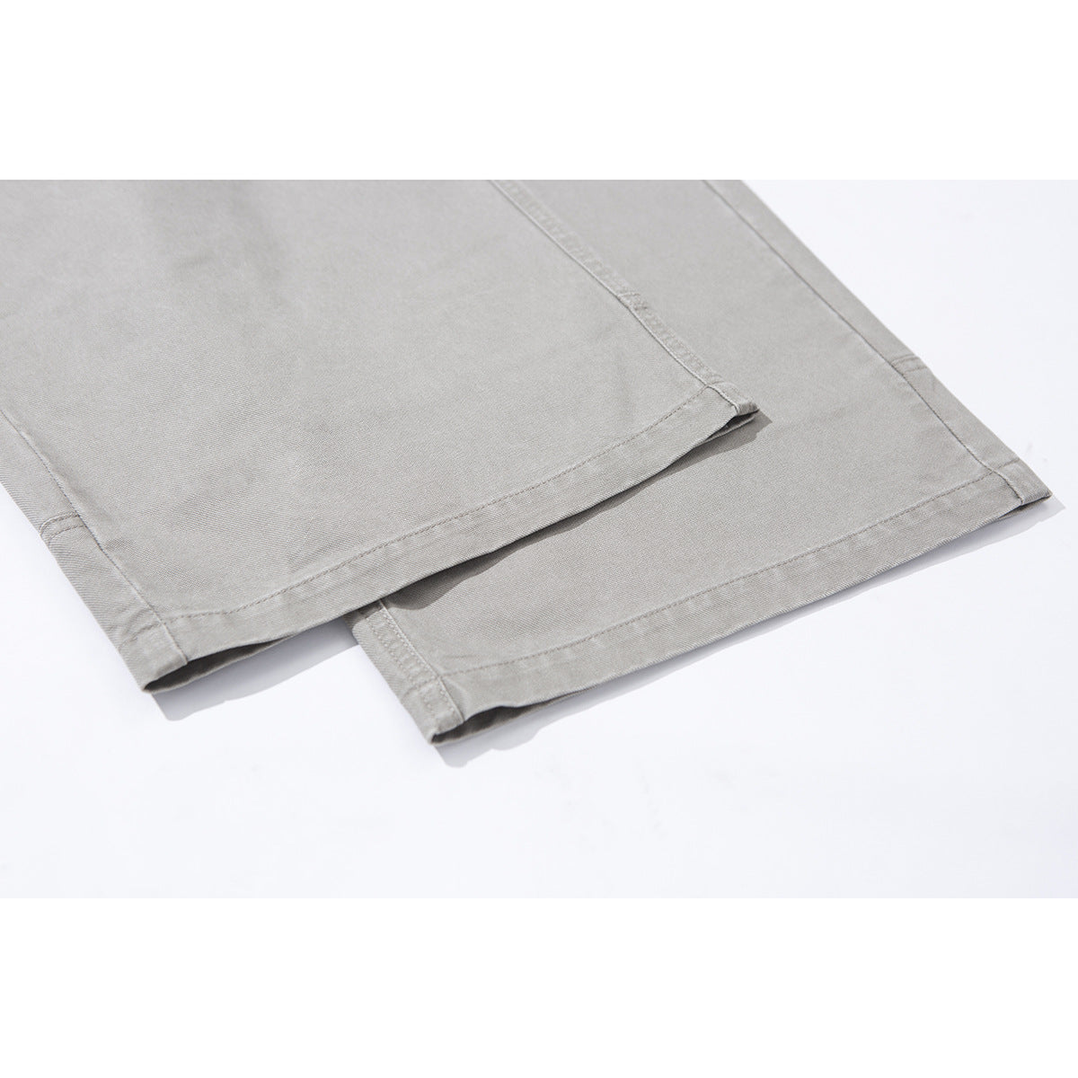 Close-up of light gray trouser legs showing the stitched hems.