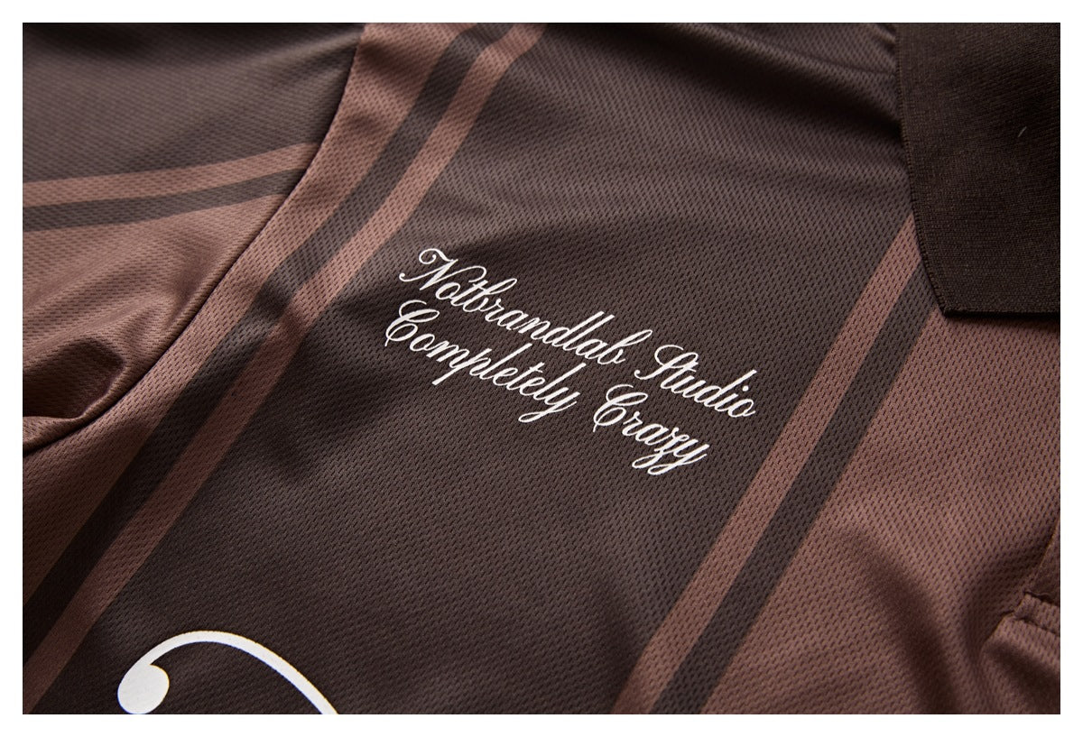 Close-up of a brown-and-dark striped mesh polo with white cursive lettering on the chest.