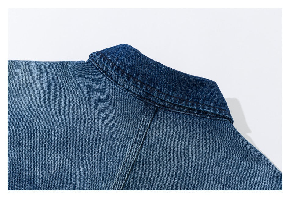 Close-up of the collar and shoulder seam on a faded blue denim shirt.