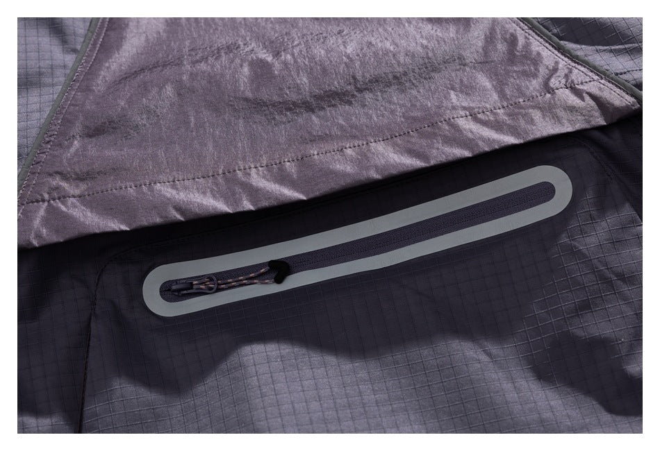 Close-up of a charcoal grid-patterned jacket with a long, sealed zipper and cord pull.