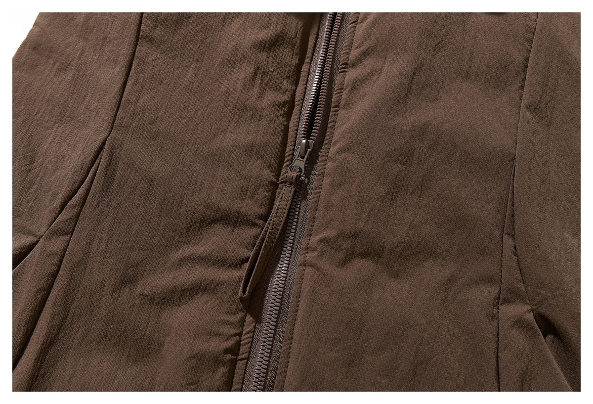 Close-up of the brown jacket's front zipper, fabric panels and zipper pull.