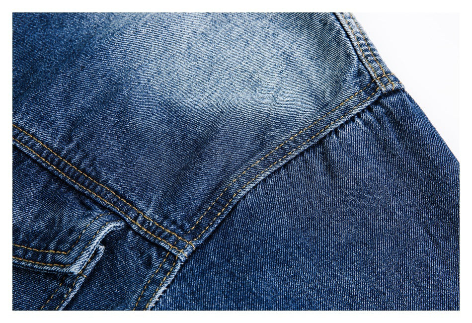 Close-up of blue denim with contrasting gold stitching and a curved seam.