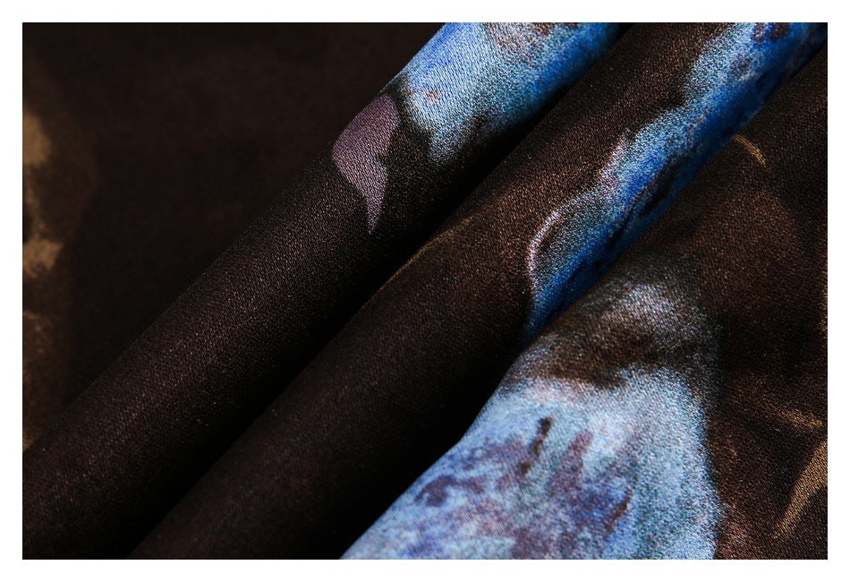 Extreme close-up of the dark brown shirt fabric with blue, tan, and pale abstract print.