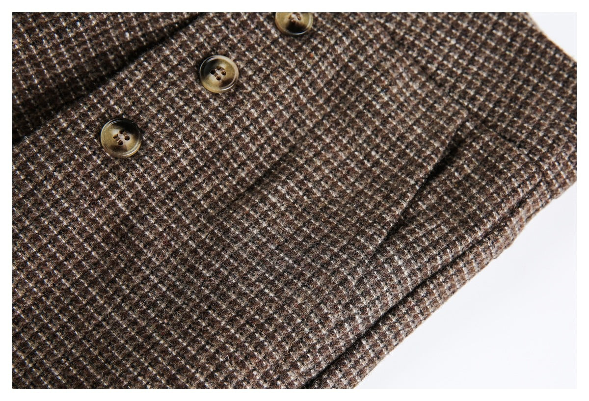 Close-up of brown small-check trouser fabric, stitching and several brass-tone buttons.