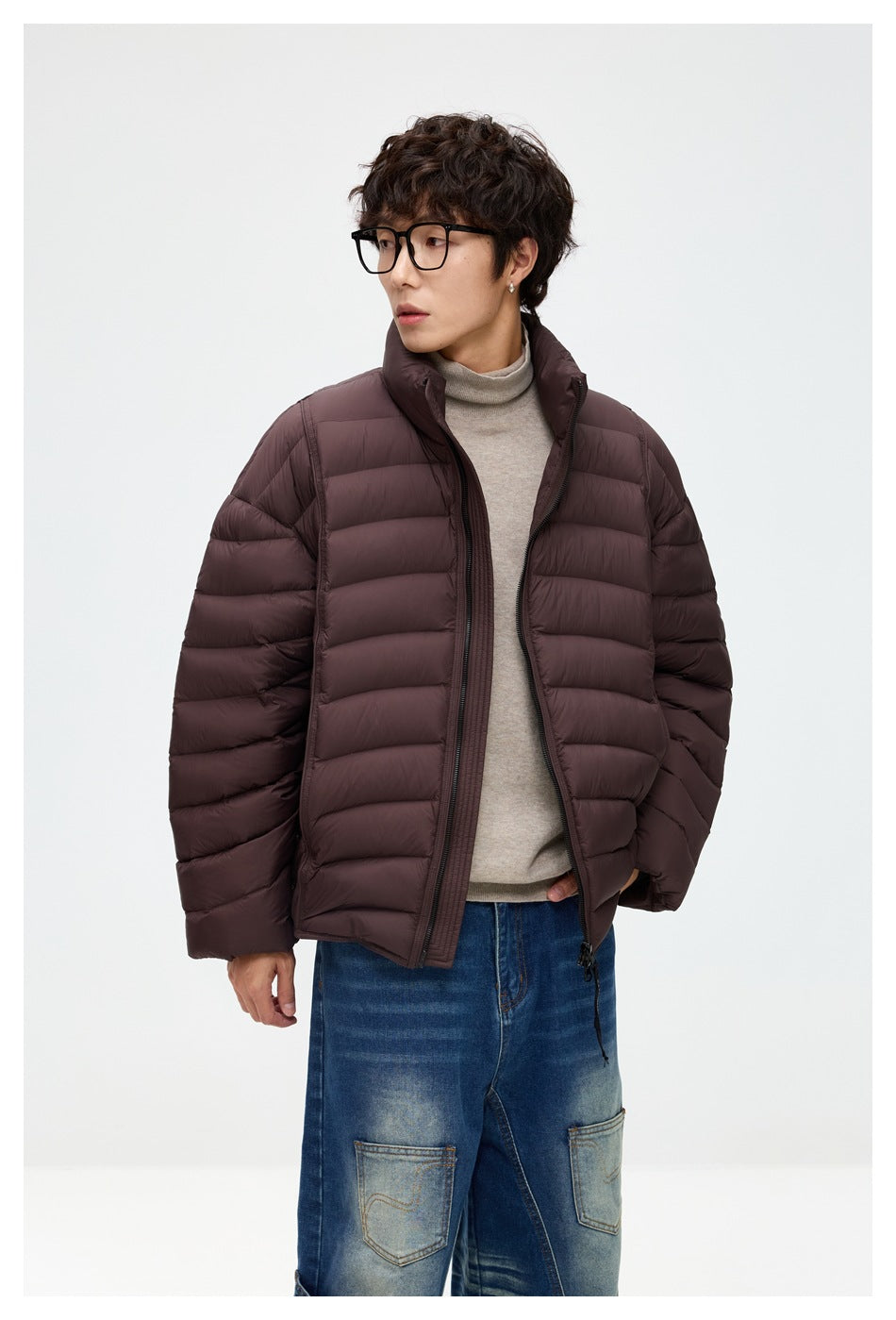 Model wearing a dark plum-brown quilted puffer jacket with a high collar and front zipper.