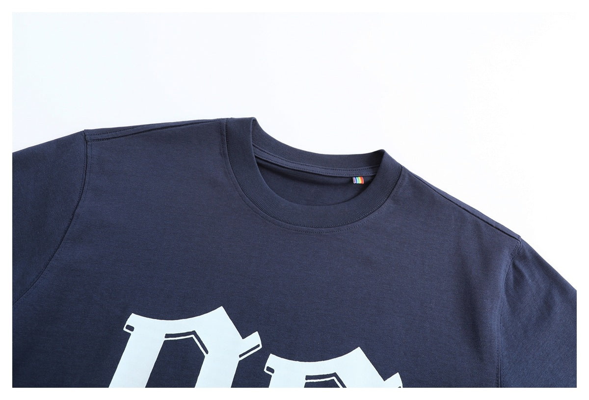 Close-up of a navy crew-neck T-shirt showing the collar, shoulders and partial white Gothic-style chest graphic.