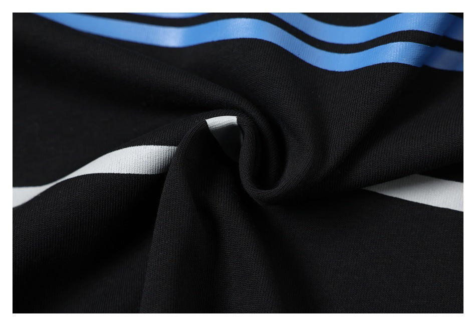 Close-up of black fabric gathered into folds, showing blue and white stripes.