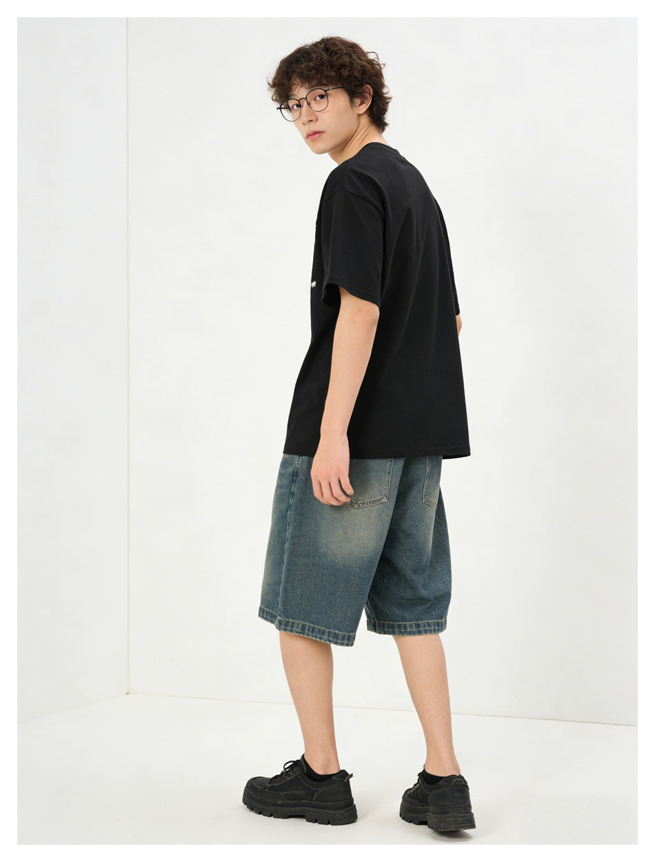 Model in a black short-sleeve T-shirt and blue denim shorts, shown from a rear three-quarter angle.