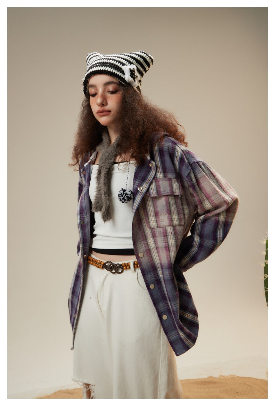 Model in a purple plaid snap-front jacket with chest pockets, shown at an angle with a striped knit hat.