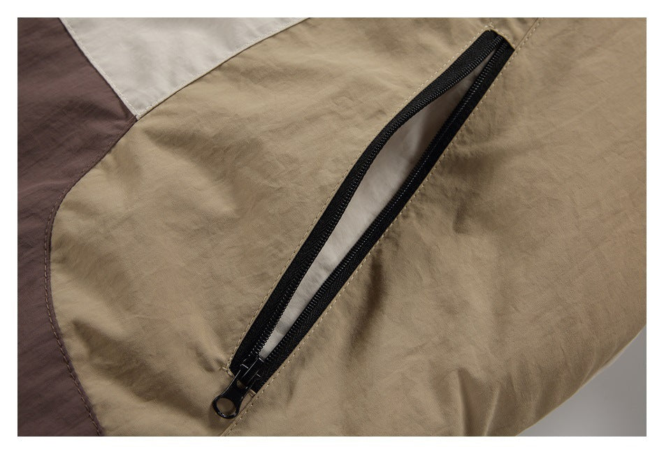 Close-up of a black zipper pocket on the tan color-block panel of the jacket.