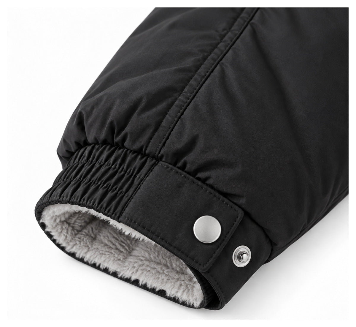 Close-up of a black jacket cuff with snap buttons and soft gray plush lining.