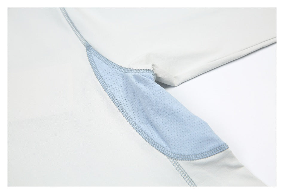 Inside view of an off-white garment with a pale blue mesh seam insert and overlock stitching.