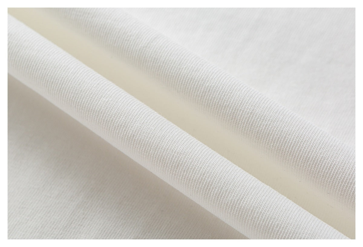 Close-up of white fabric folded over to show its ribbed edge and surface texture.