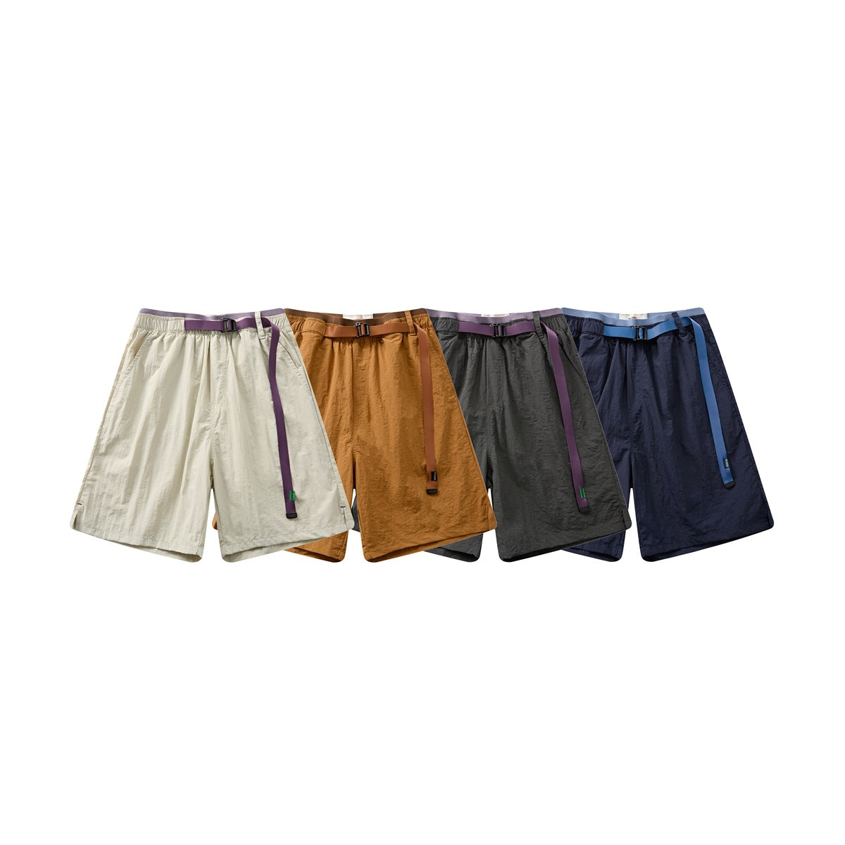 Four pairs of belted shorts shown together in cream, ochre, charcoal gray, and navy.