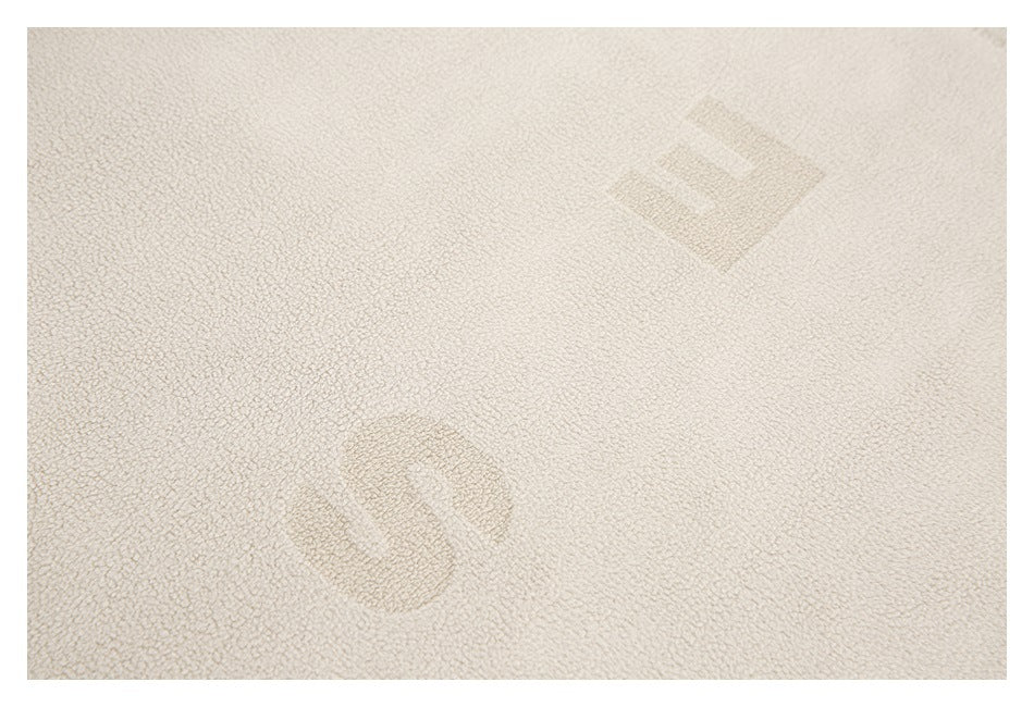 Close-up of cream loop-textured fabric with faint tonal geometric shapes.