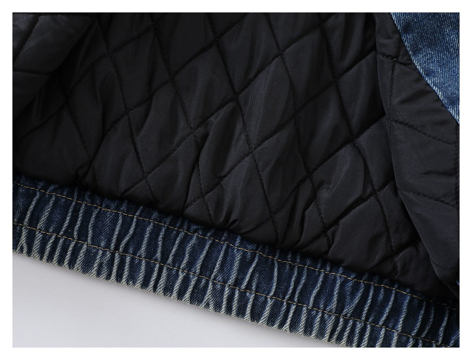 Close-up of black diamond-quilted lining joined to a blue denim edge with visible stitching.