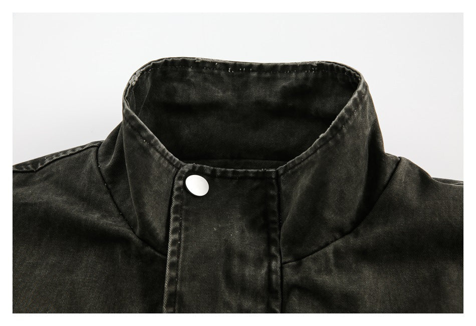 Close-up of a dark washed jacket's high collar and silver snap fastening.