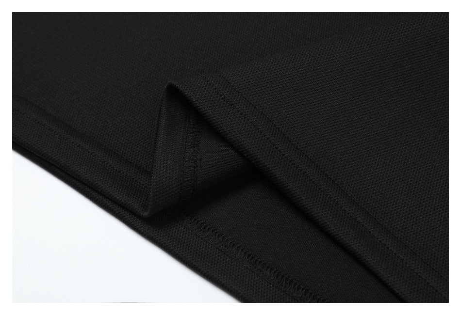 Close-up of a black garment hem showing the folded edge and stitching.
