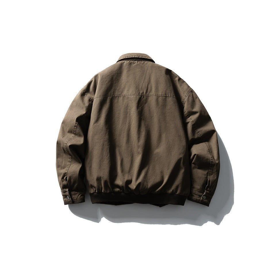Back view of the brown jacket, showing its plain panel, shoulder seam, sleeves, and dark ribbed hem.