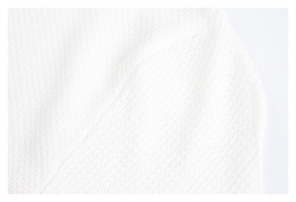 Close-up of the white knit garment's textured fabric and curved edge.