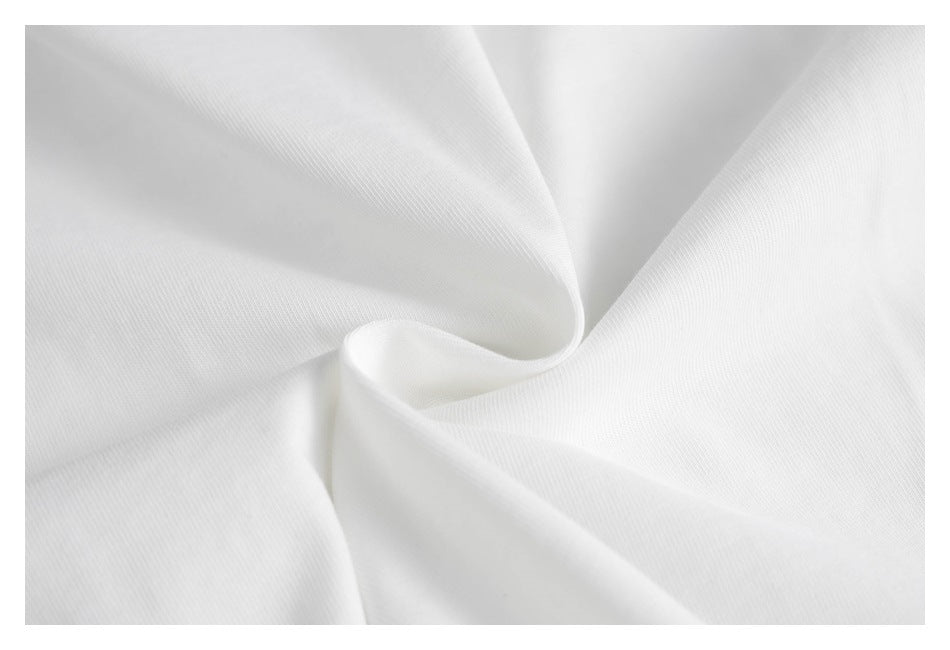 Close-up of white shirt fabric gathered into soft folds, showing its fine surface texture.