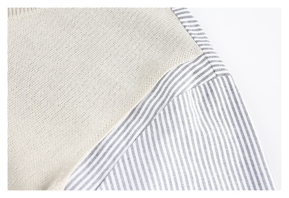 Close-up of cream textured fabric beside white fabric with fine navy stripes.