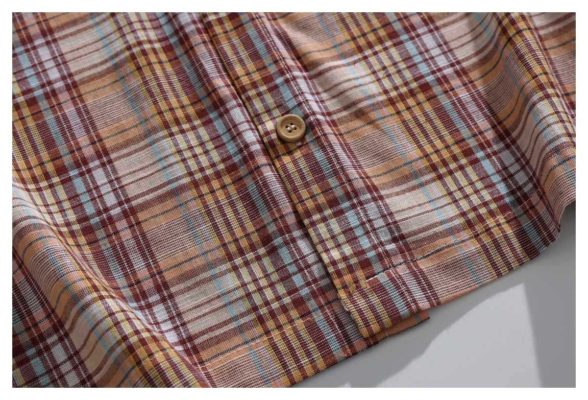 Close-up of the plaid shirt front and button placket, with a tan button and intersecting colored checks.