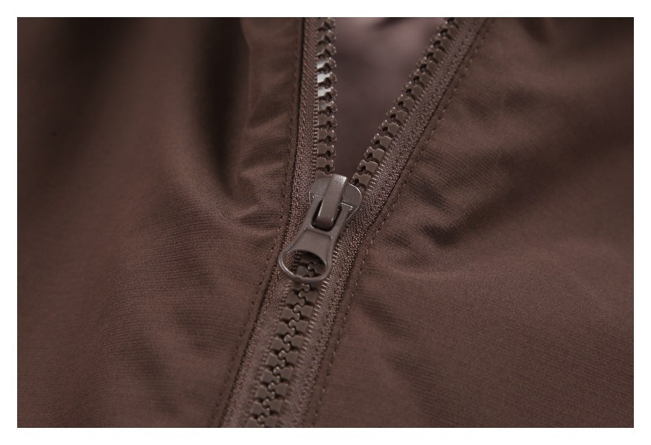 Close-up of a dark brown jacket's chunky front zipper and matching fabric.