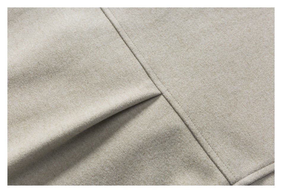 Close-up of beige woven fabric showing a seam and a folded, stitched edge.