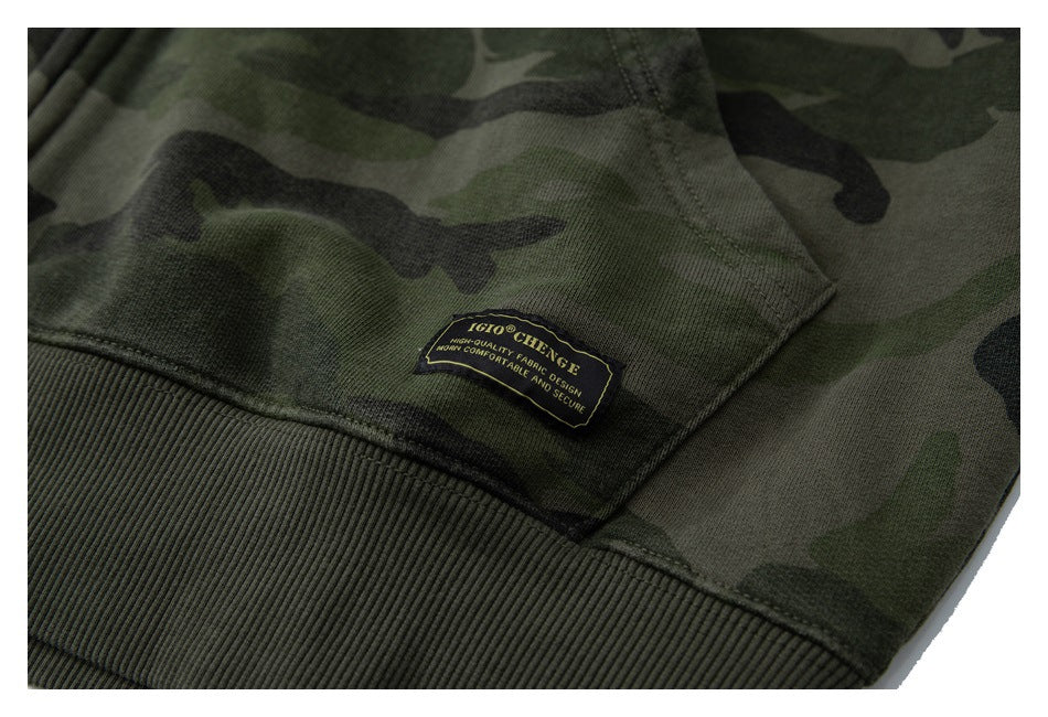 Close-up of the ribbed hem and sewn English text label on an olive camouflage hoodie.