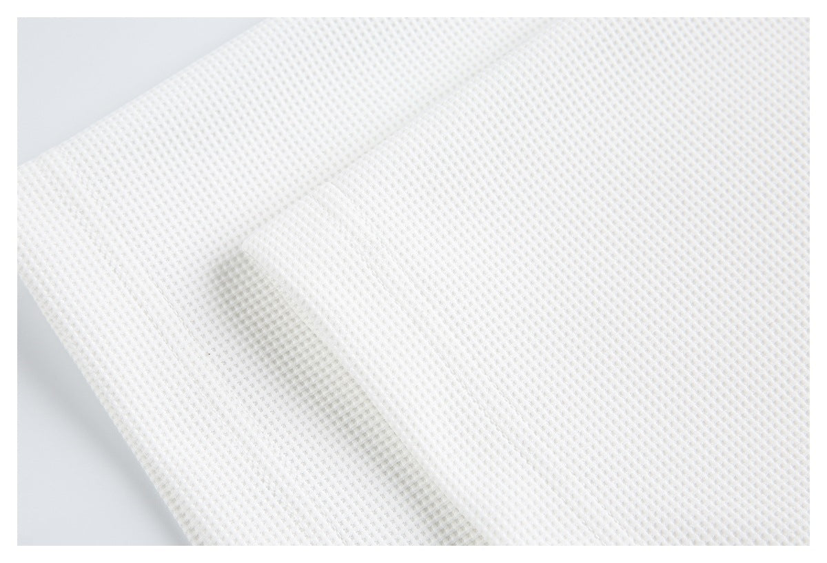 Close-up of the white waffle-knit fabric and its raised grid texture.