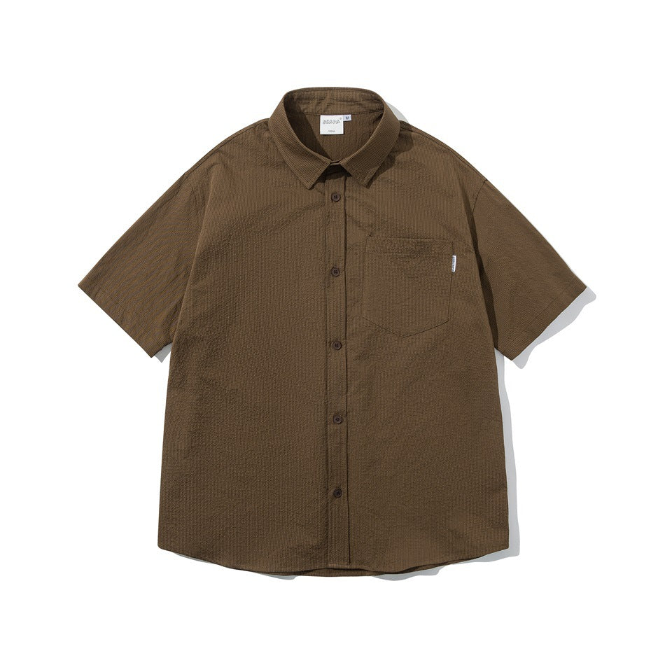 Brown short-sleeve button-up shirt with chest pocket and textured fabric, flat front view