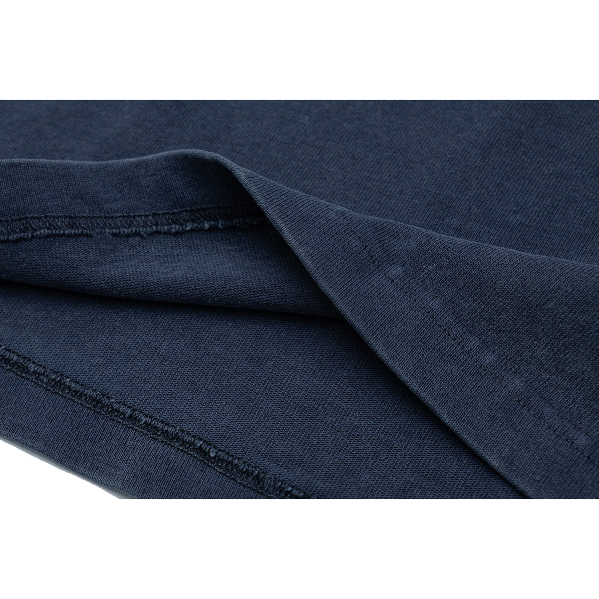 Close-up of navy T-shirt fabric folded to show the inside and stitched hem.