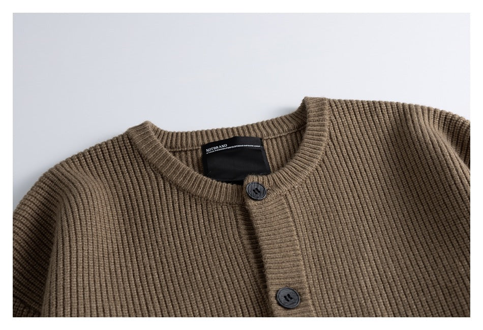 Close-up of the taupe-brown ribbed cardigan's crew neckline, button placket and sewn neck label.