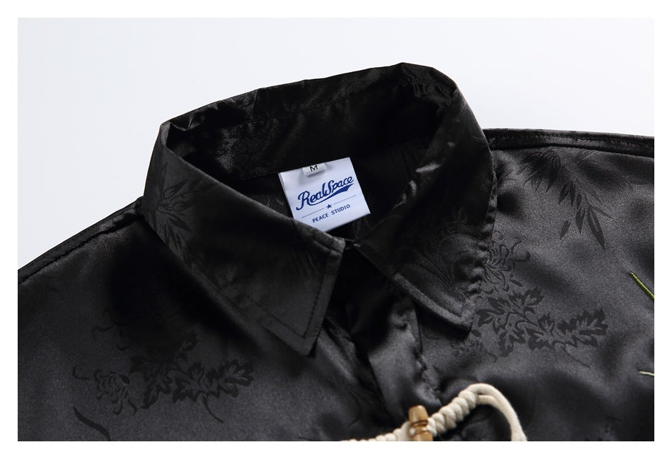 Close-up of a black floral-patterned shirt collar with a sewn neck label.